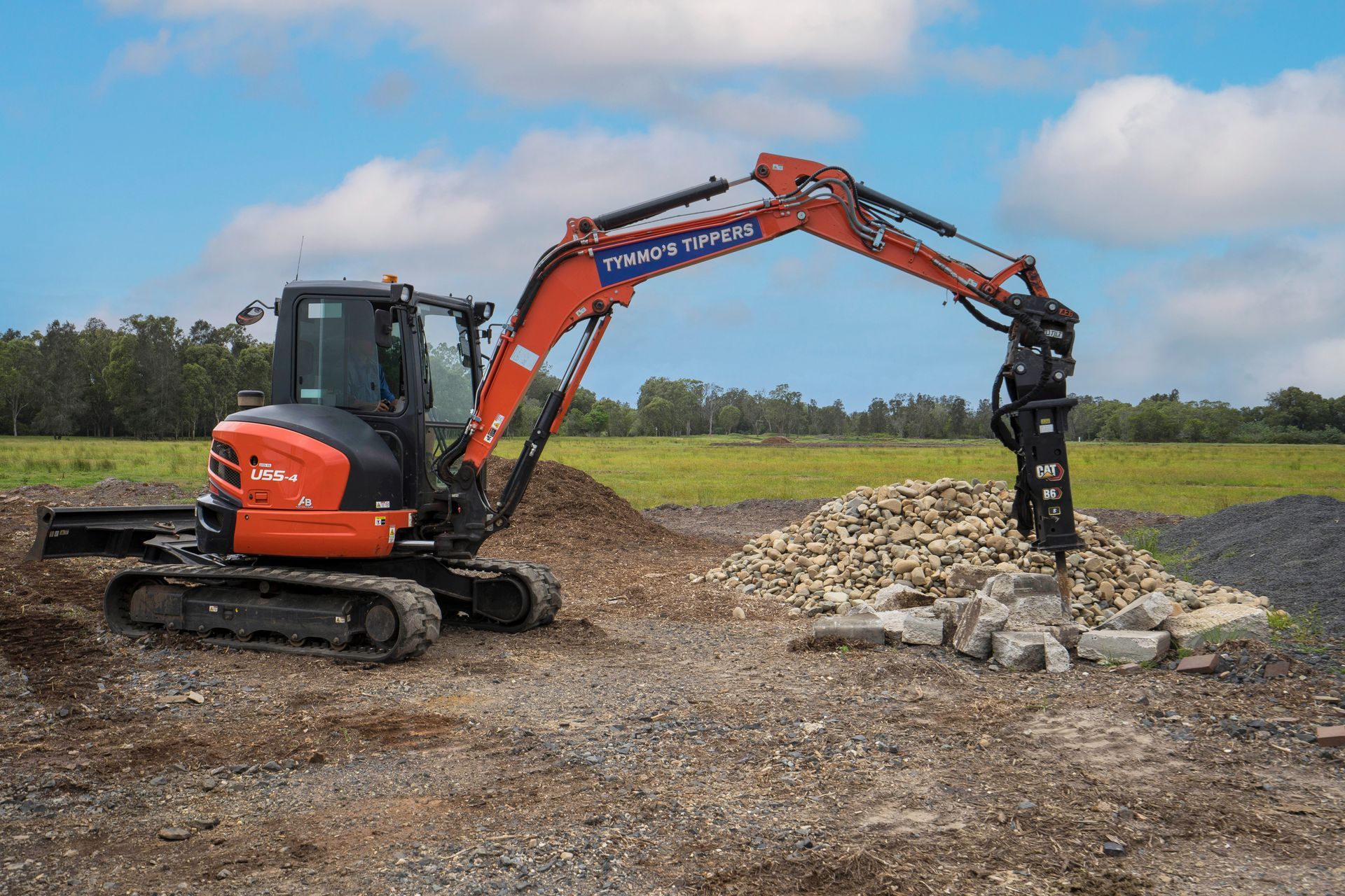 A Yellow Excavator Is Loading Gravel Into A Dump Truck — Tymmo's Tippers In West Ballina, NSW