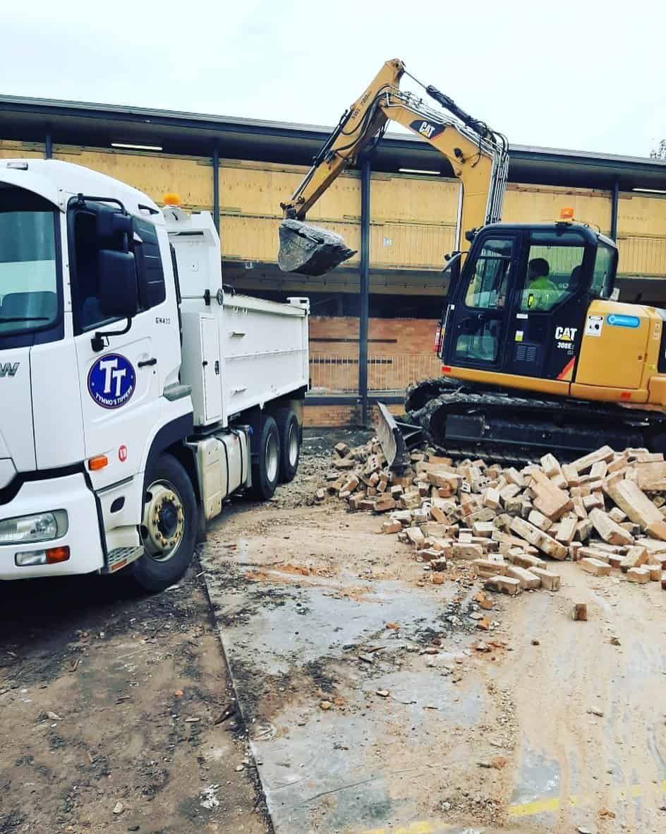 A Dump Truck Is Being Loaded With Bricks Next To An Excavator — Tymmo's Tippers In Byron Bay, NSW