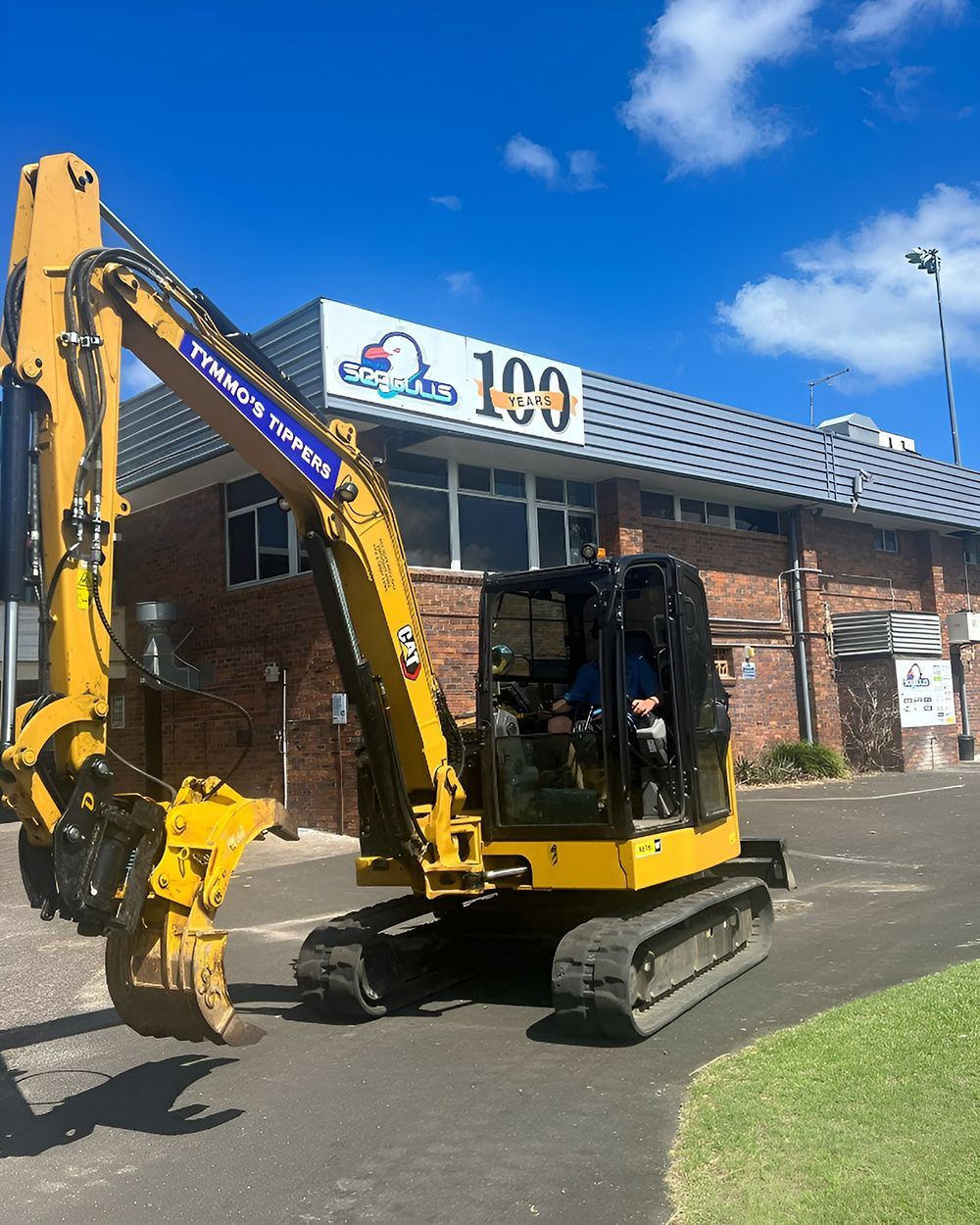 A Yellow Excavator With A Dark Metal Bucket — Tymmo's Tippers In Lismore, NSW