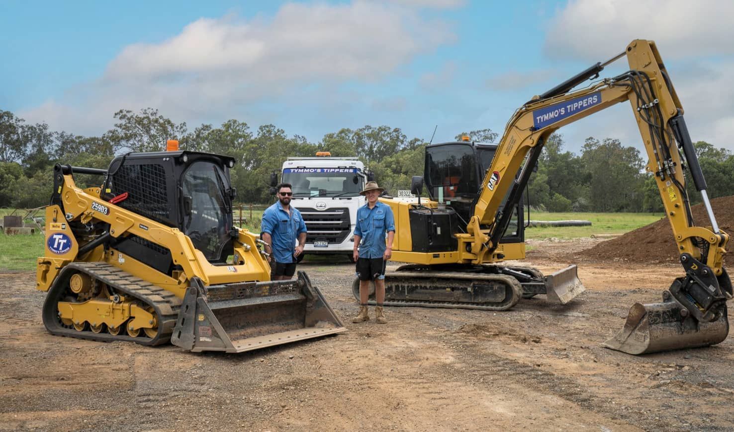 Two Men Are Standing Next To A Bulldozer And An Excavator — Tymmo's Tippers In Yamba, NSW