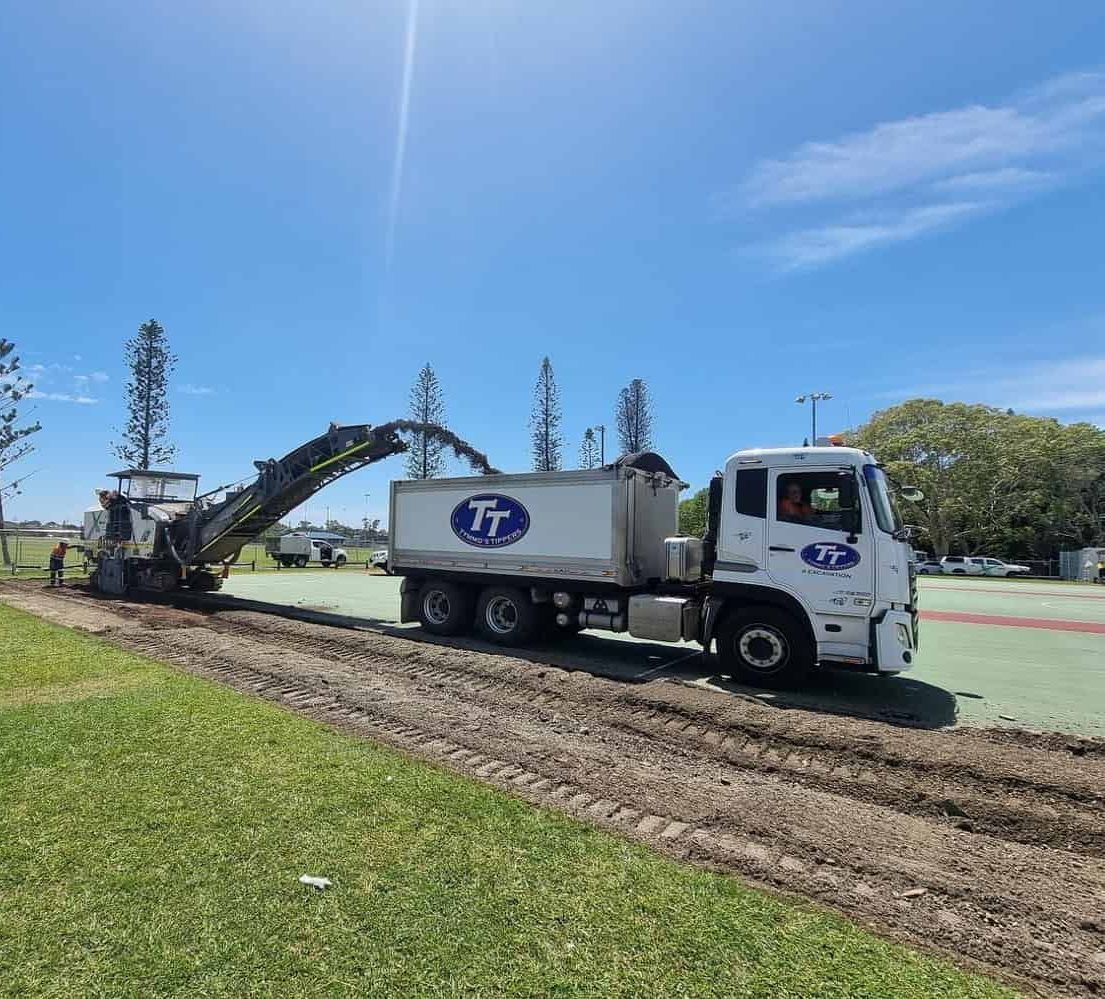 A Truck Is Driving Down A Dirt Road With A Machine Attached To It — Tymmo's Tippers In Ballina, NSW