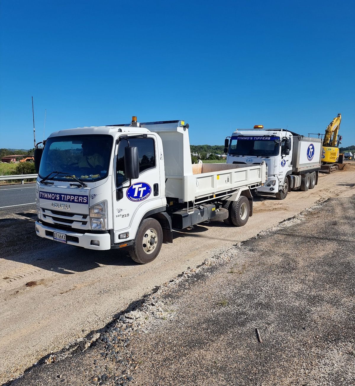 Two White Trucks with a Logo at a Construction Site — Tymmo's Tippers In Byron Bay, NSW