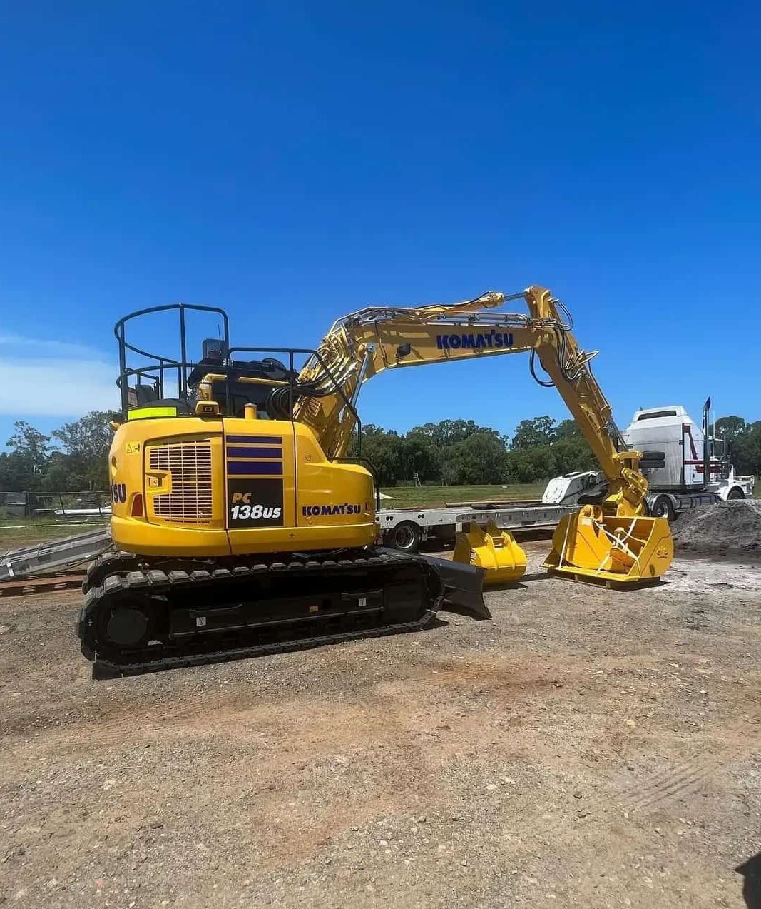 A Yellow Komatsu Excavator Is Parked In A Gravel Lot — Tymmo's Tippers In Tweed Heads, NSW