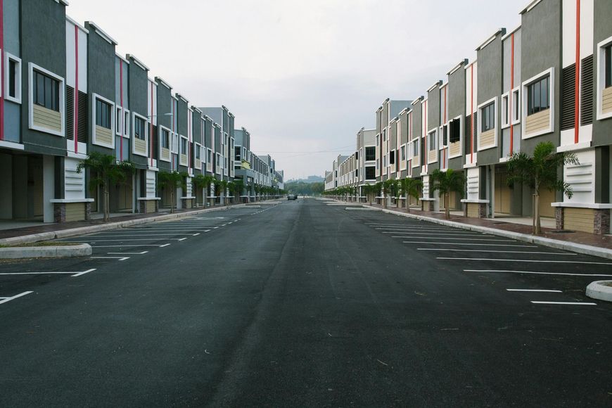 Rows of gray and white townhouses with a street down the middle.