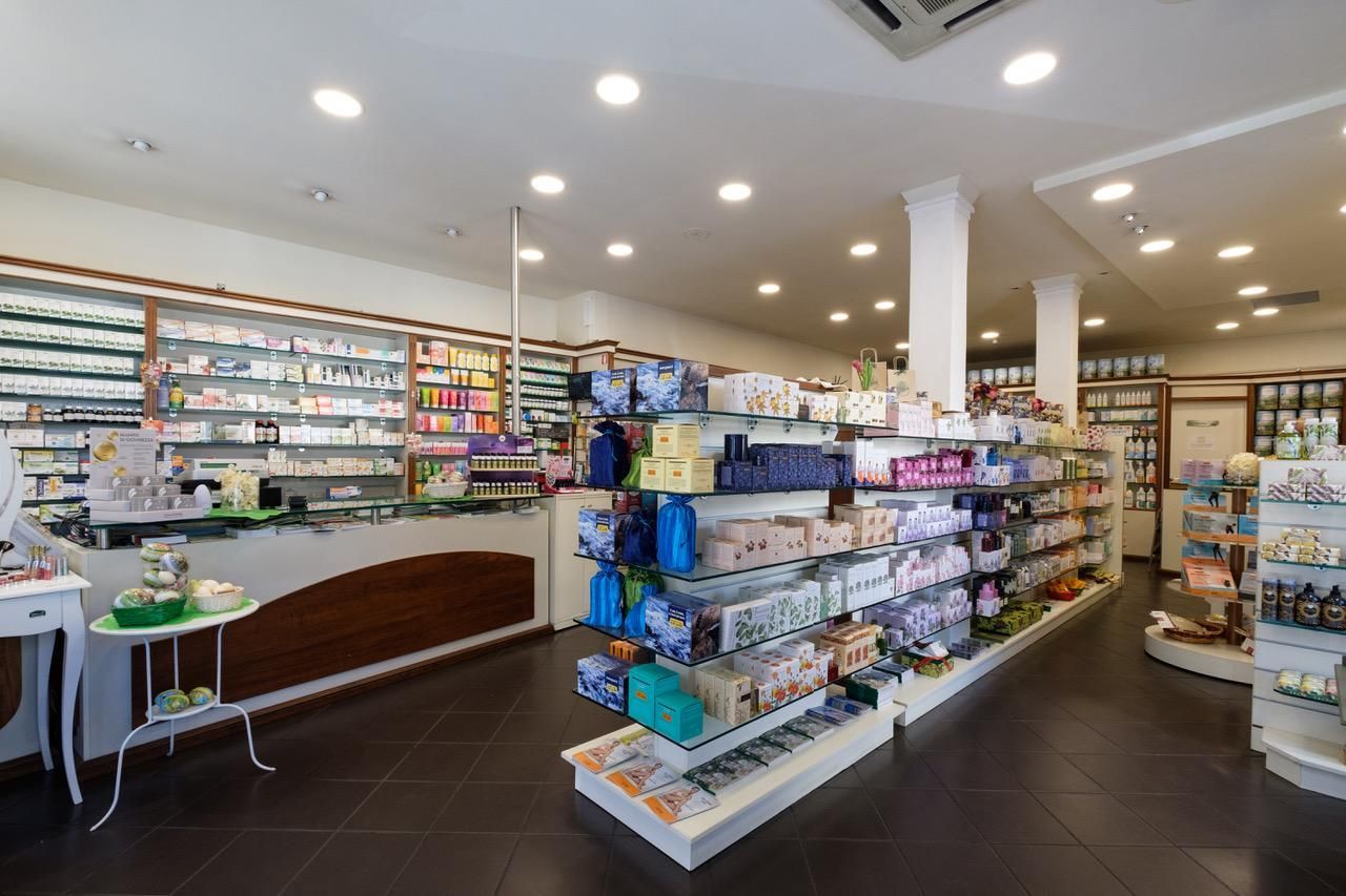 Vista interna di un'erboristeria ben illuminata con scaffali pieni di prodotti e un bancone.