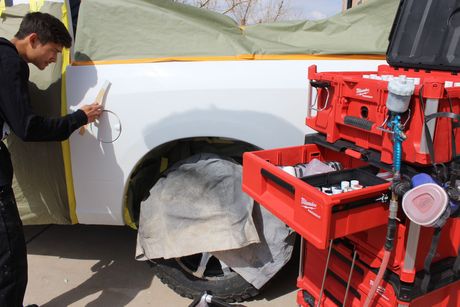 a technician color matching a white truck using mobile automotive  paint correction kit .