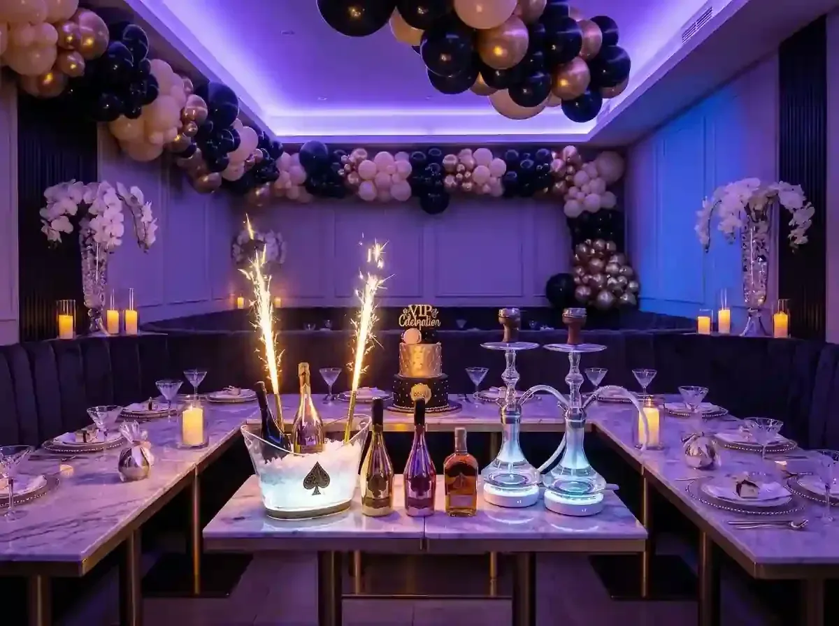 Elegant banquet table in a purple-lit room with gold balloon garlands 