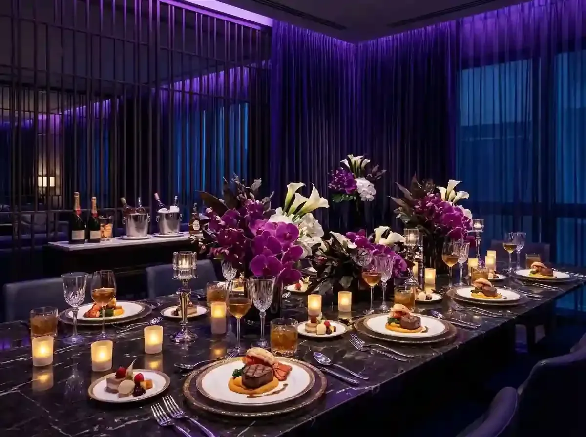Elegant dinner table with purple floral centerpieces and candlelight in a dimly lit lounge