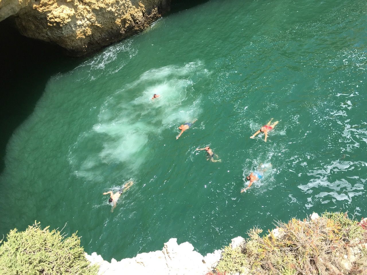 a group of people are swimming in a body of water in Albufeira, Portugal