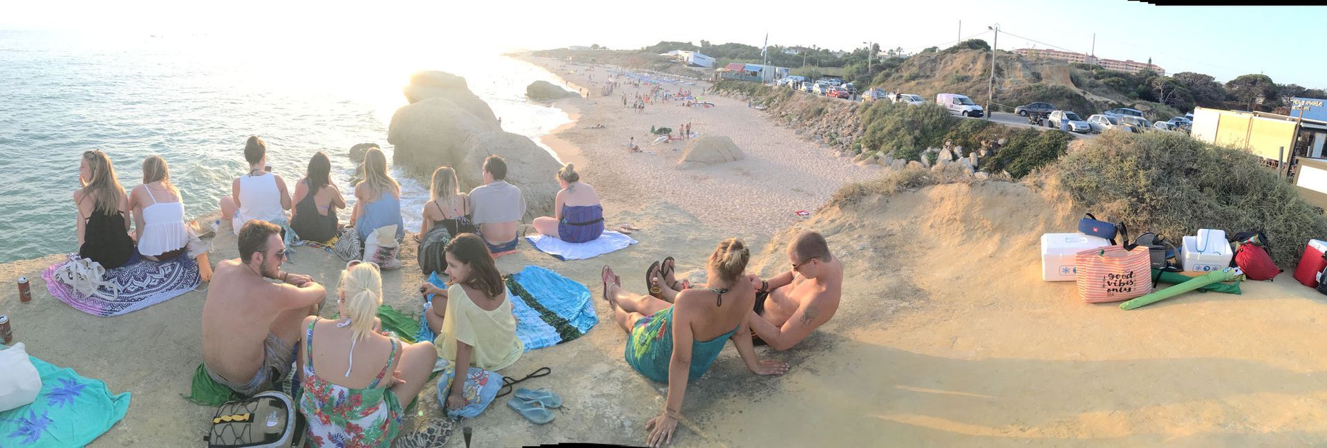 a group of people are sitting on the beach near the ocean in Albufeira, Portugal.