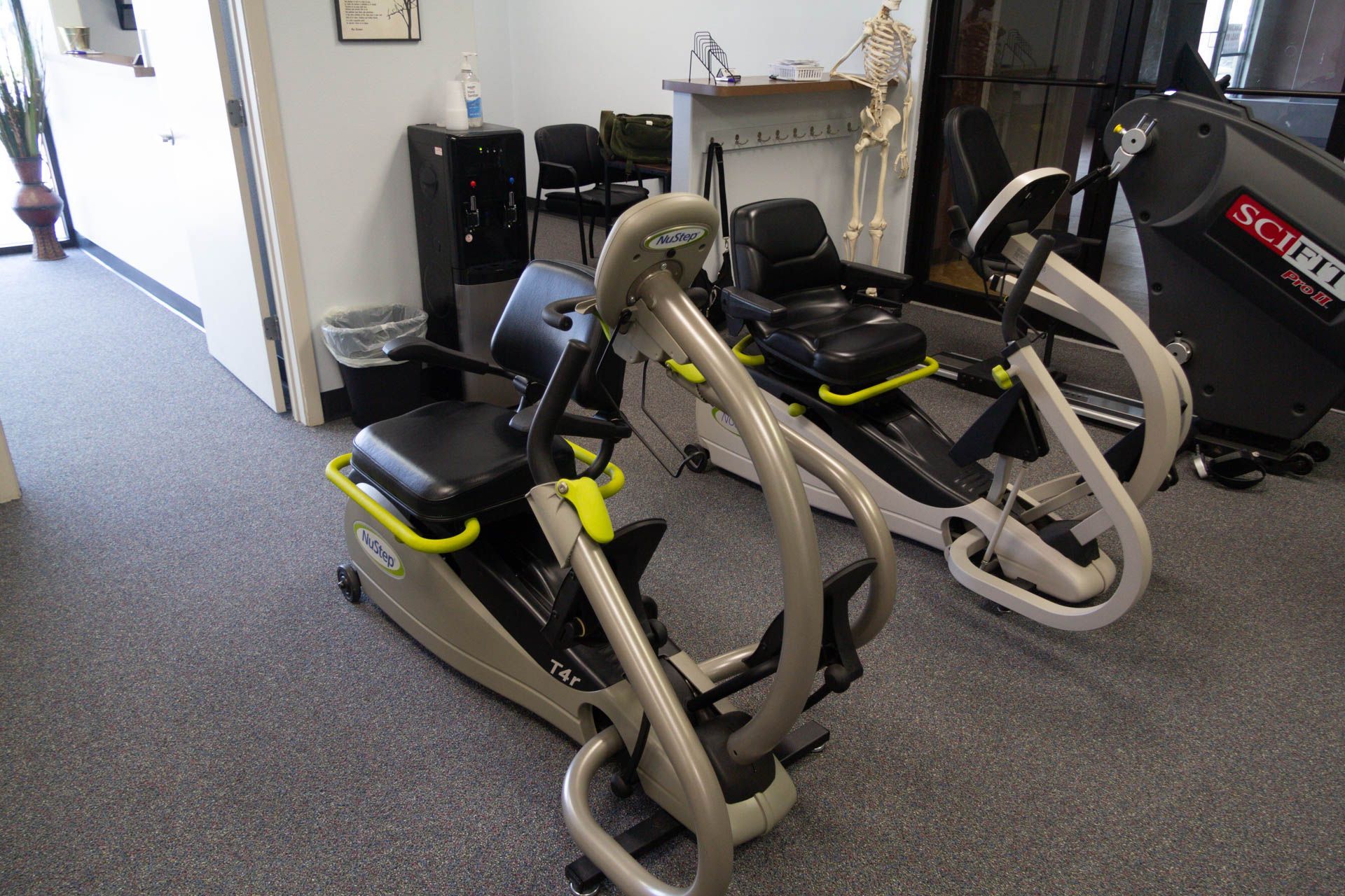 Two exercise bikes are sitting in a room next to each other.