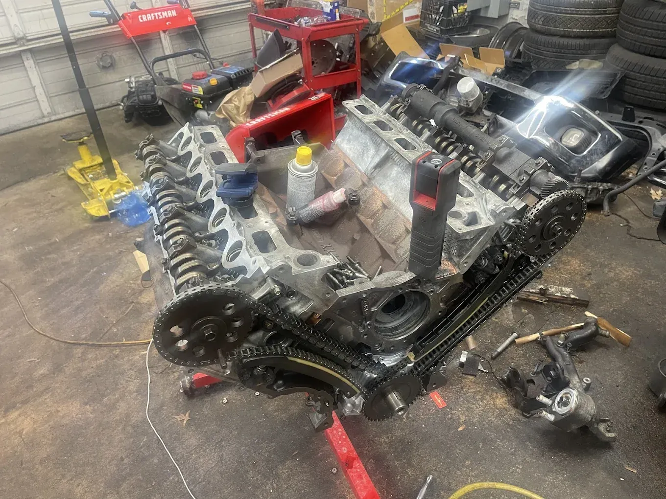 An engine in pieces, with exposed components. Workshop setting.