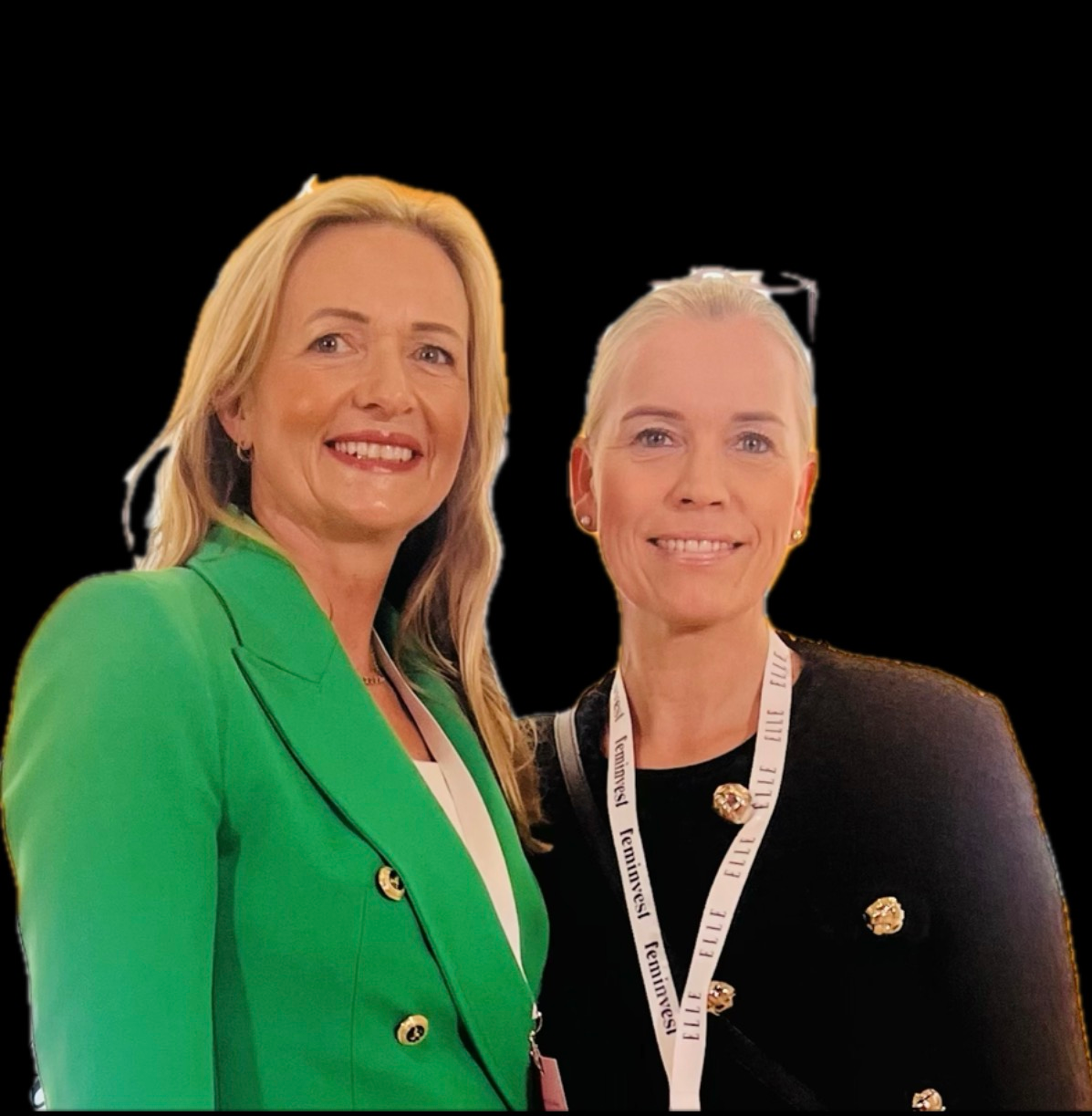 To kvinner som smiler mot svart bakgrunn, en i en grønn blazer og en med snor.