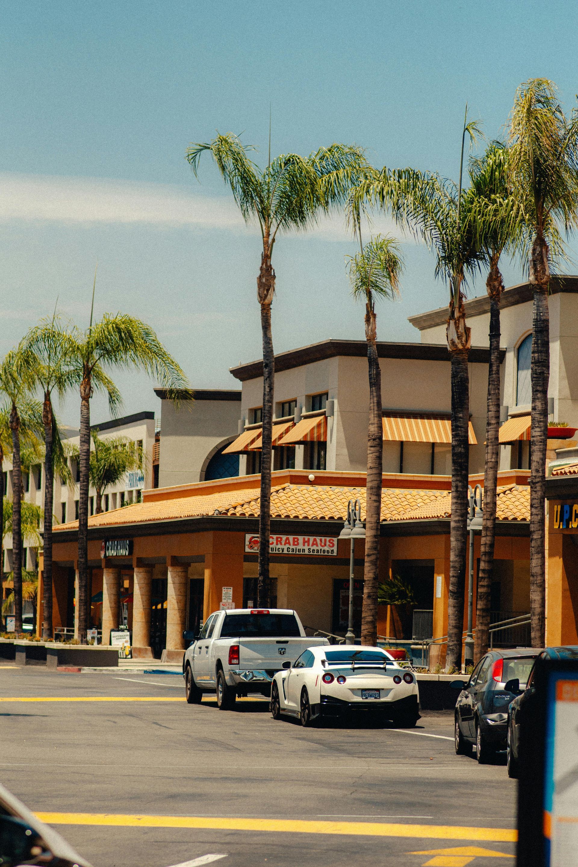 A woman is carrying a little girl on her shoulders in a field at sunset.