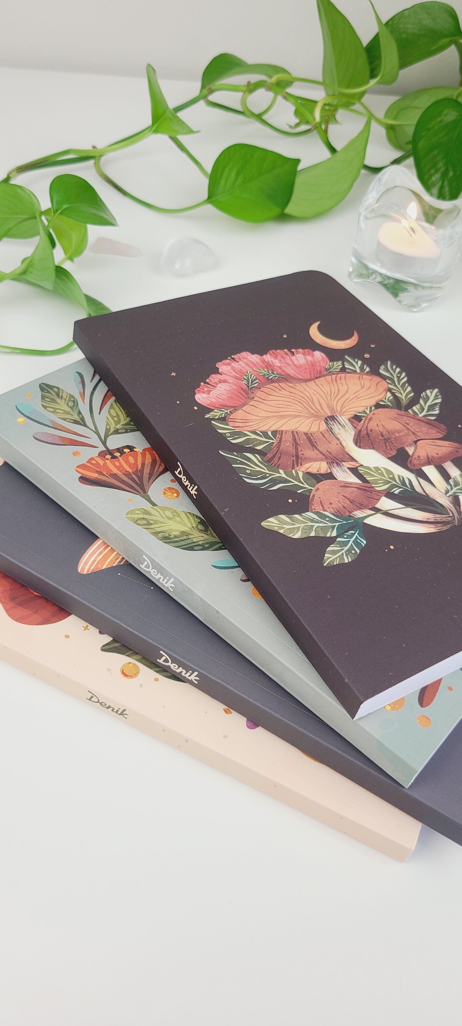 three notebooks are stacked on top of each other on a table .