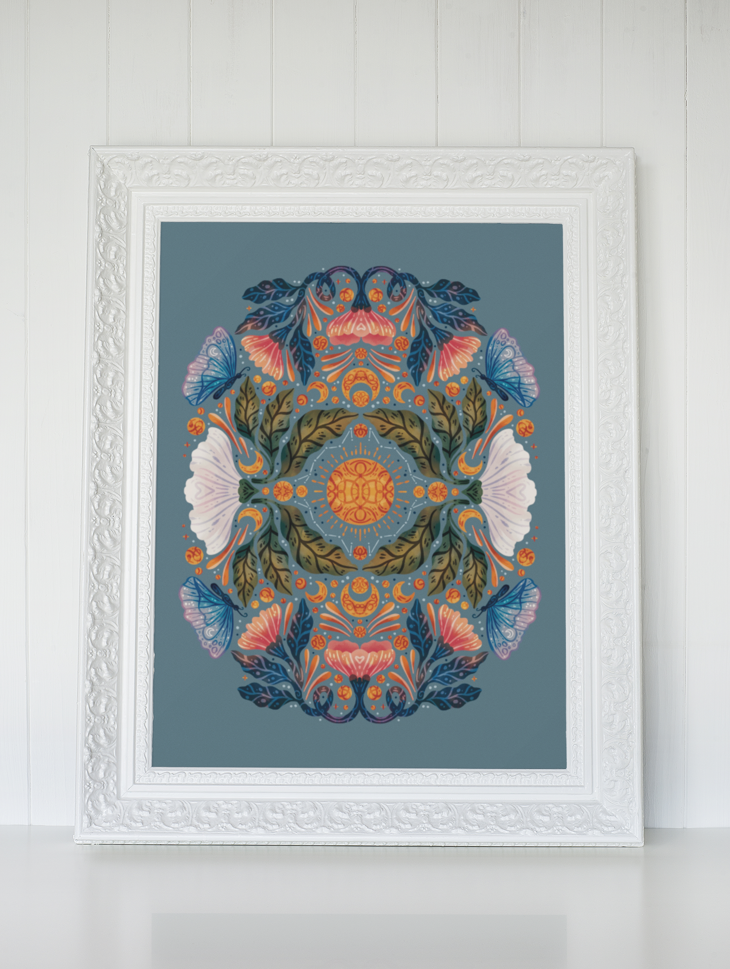 a cross stitch pattern in a white frame is hanging on a wall .