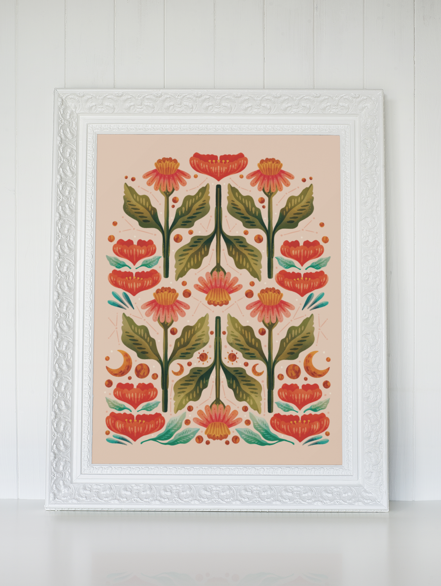 A framed painting of flowers and leaves is hanging on a wall.