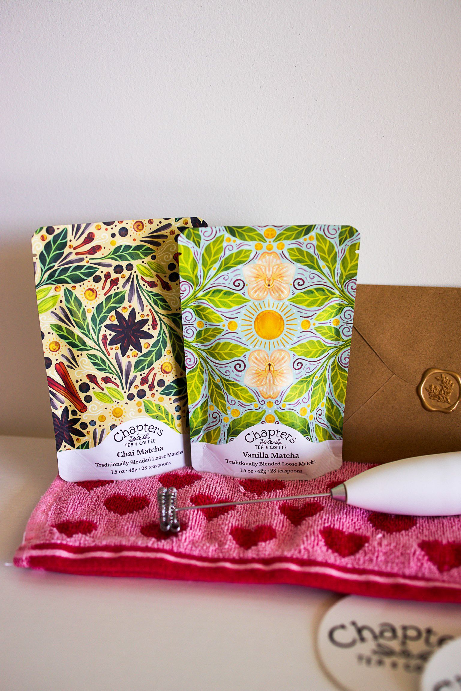 Two bags of soap are sitting on top of a pink towel on a table.