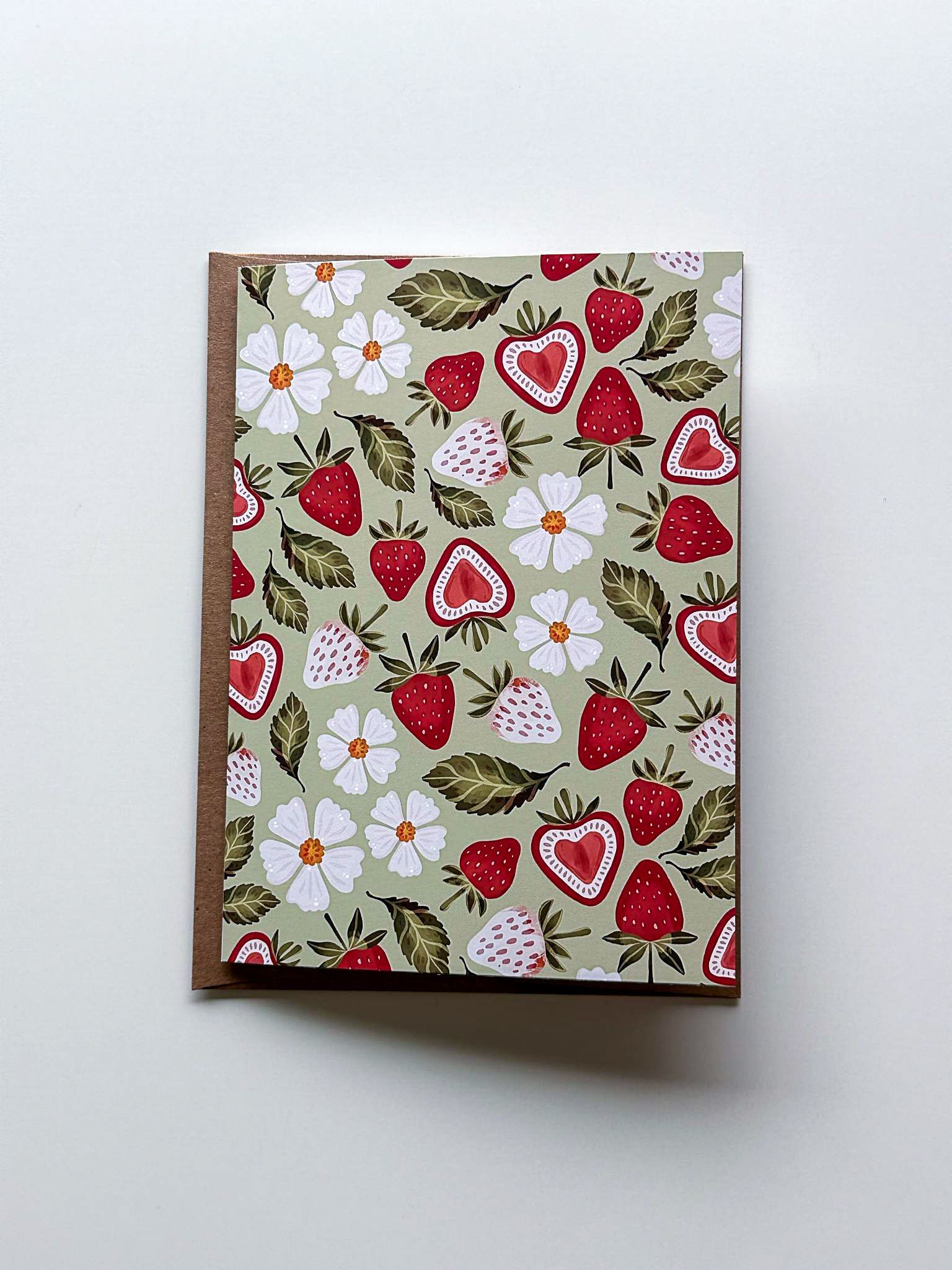 a greeting card with a painting of flowers and leaves on it .