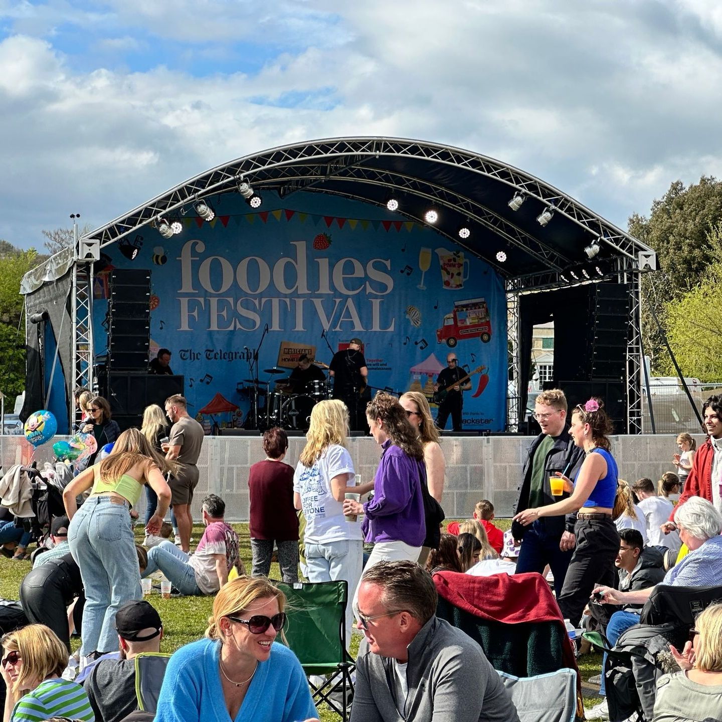 an arc truss stage with a large audience watching.