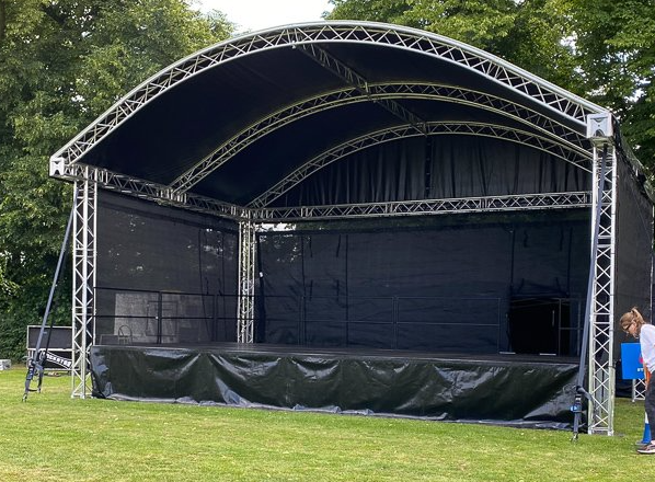 An empty Arc roofed stage with truss's and black backing and roof