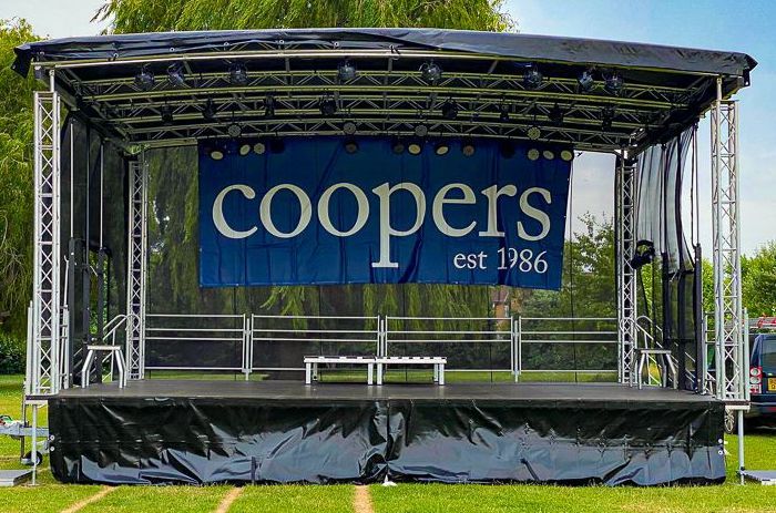 Trailer stage set up for an event in a field.