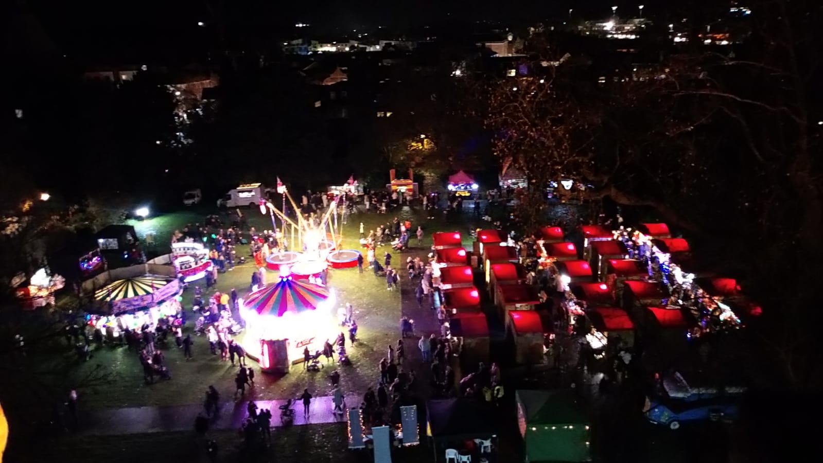 An arial shot of a Christmas market, with funfair rides and chalets