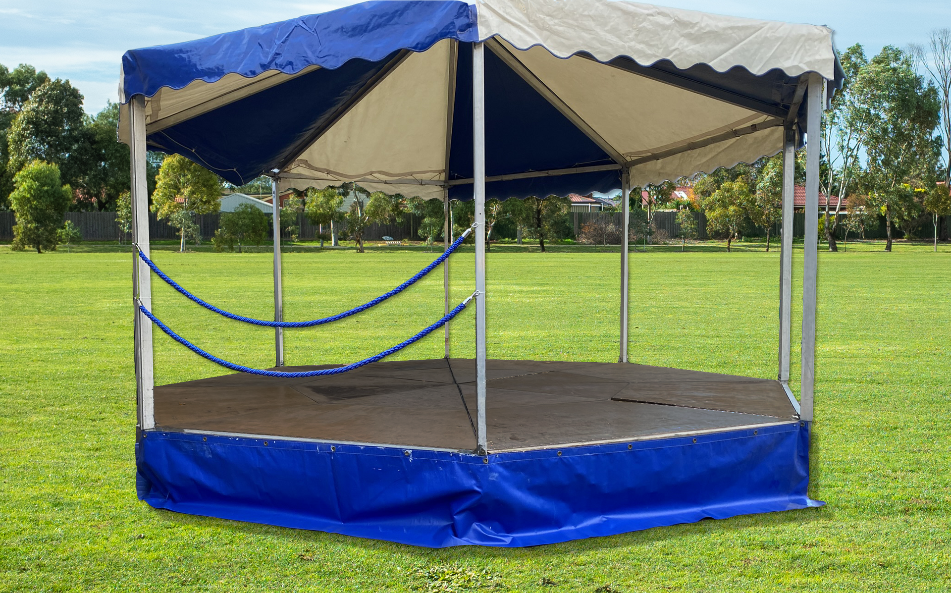 A mobile bandstand with white and blue canopy at an event