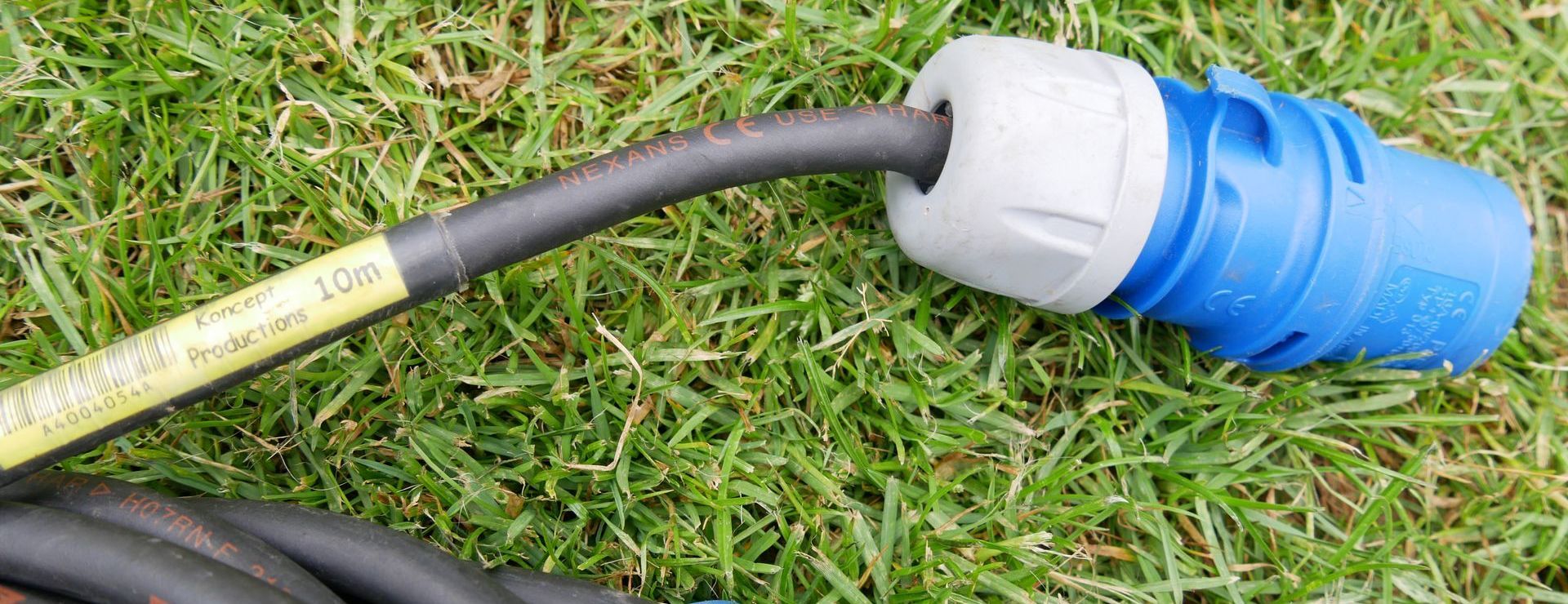 Outdoor event field with a cable with a blue plug on the end