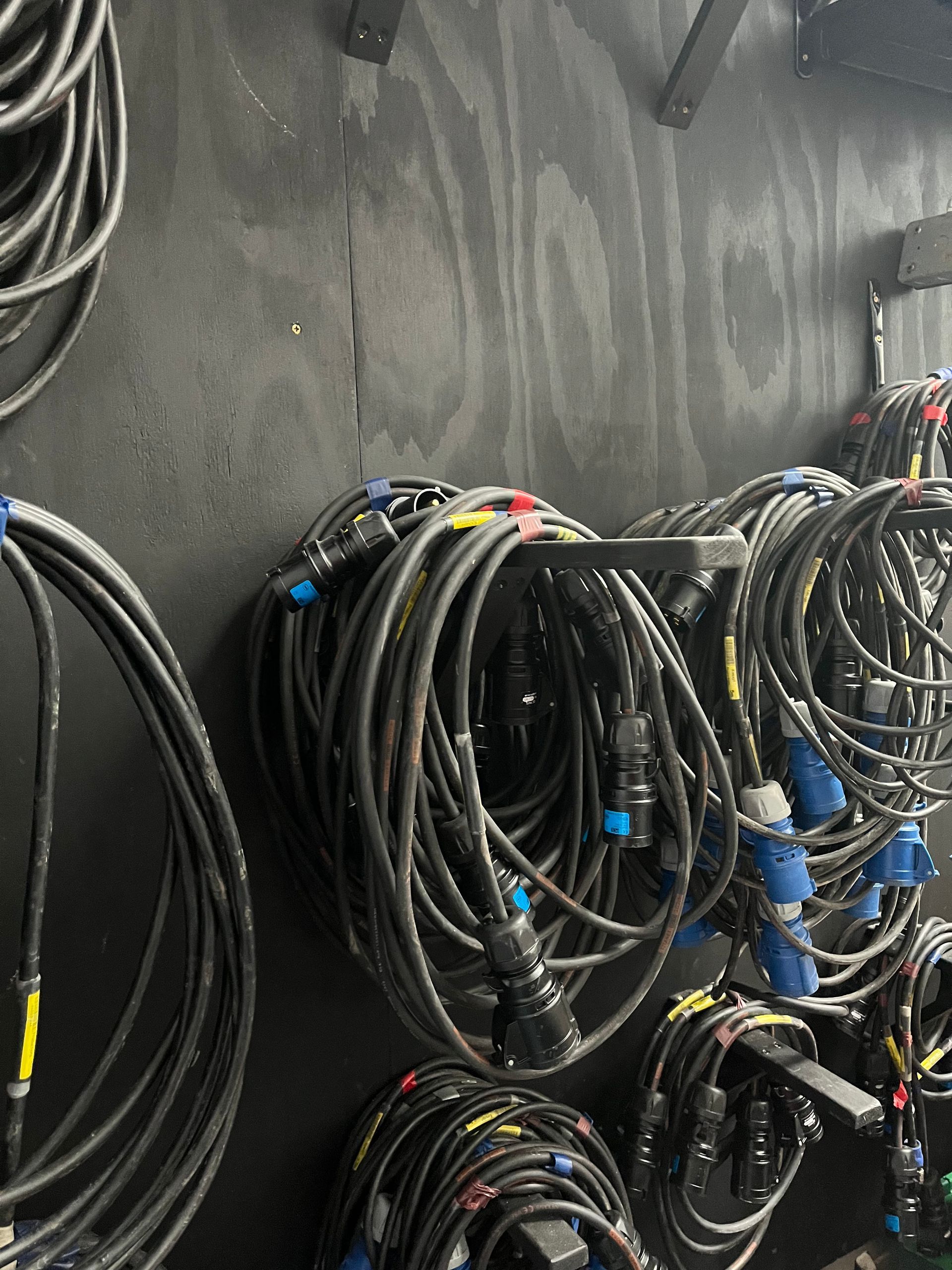 A close up of cables hanging on a warehouse wall