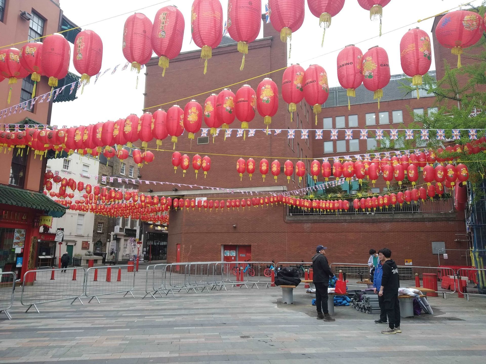 an empty square with Chinese lanterns hanging from cables