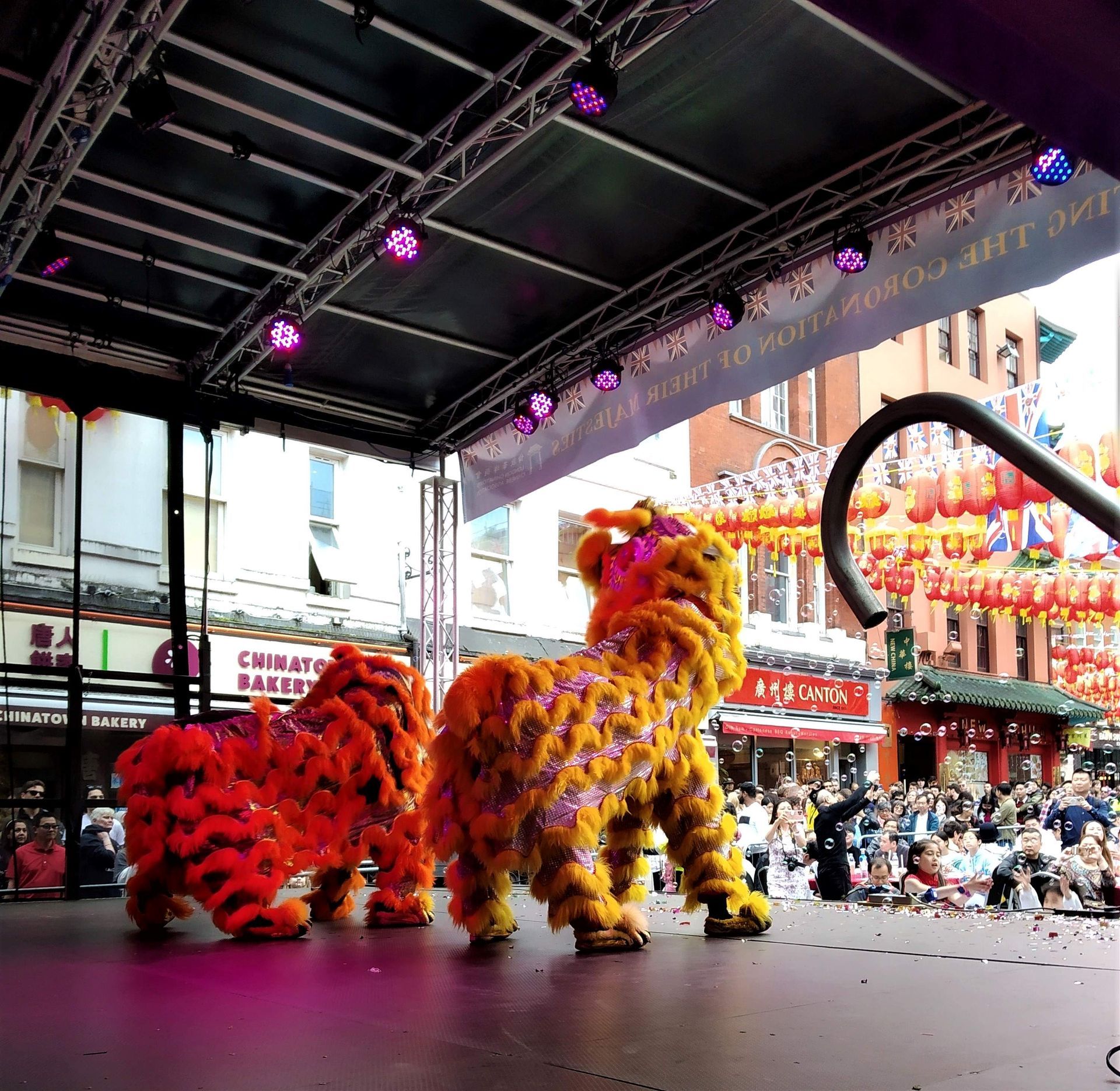 a shot of two Chinese dragons, one red one yellow from behind as they perform on stage