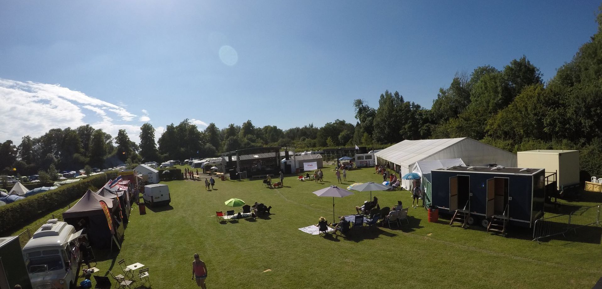 a partially set up event site with blue sky above and in a green field