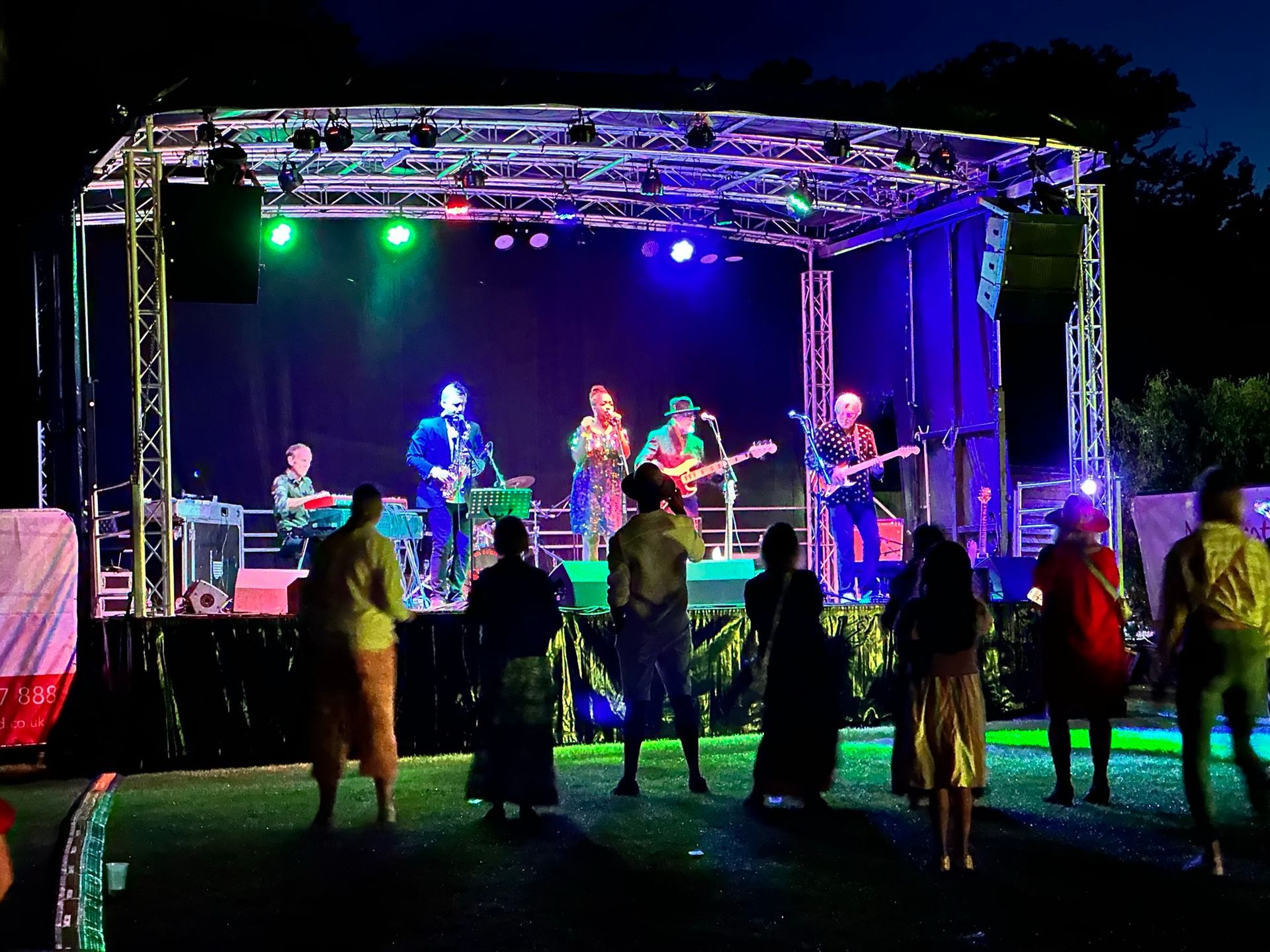 Trailer stage with lights and performers on it.