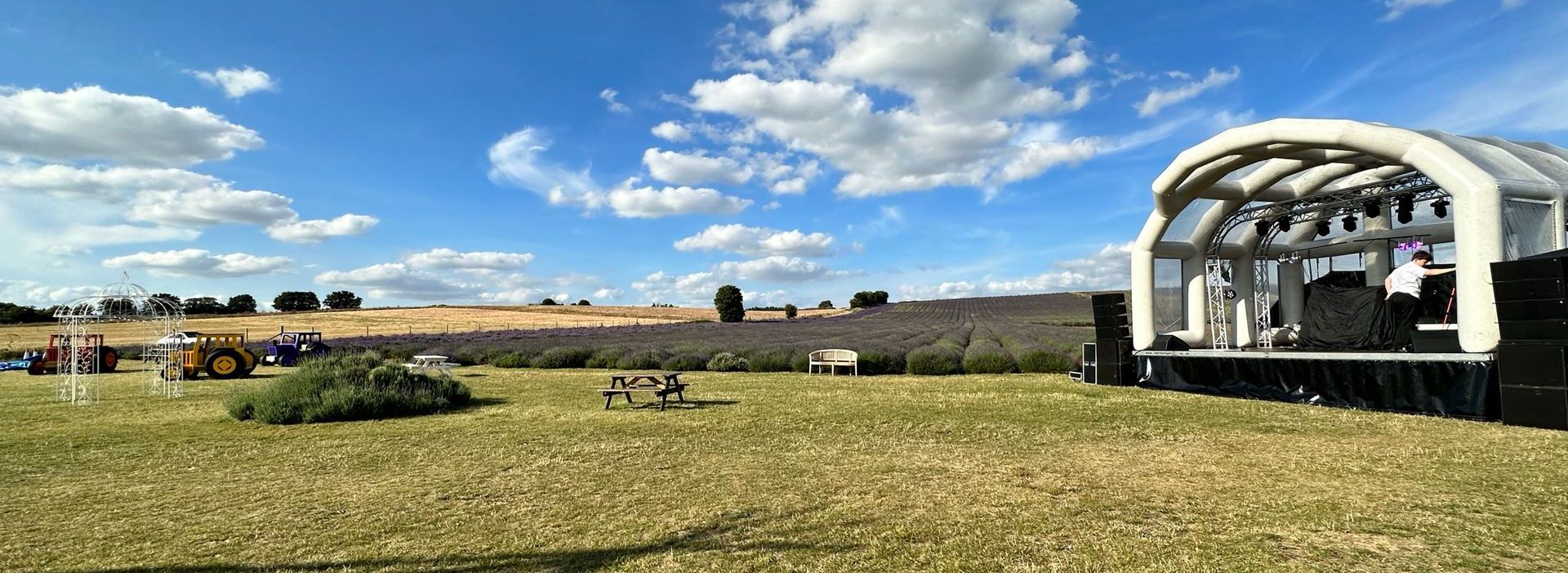 A wide shot of an inflatable stage in a field with lavender in the background.