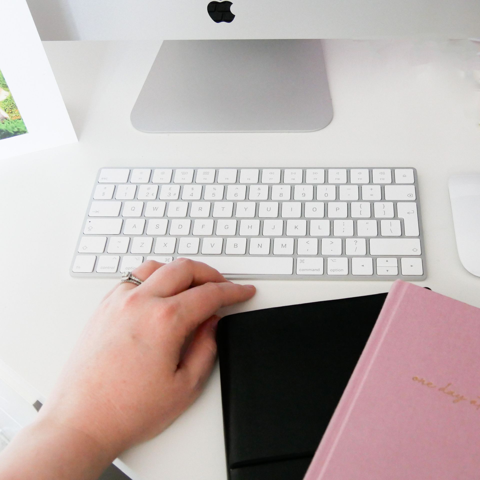 A hand with a keyboard and notebooks