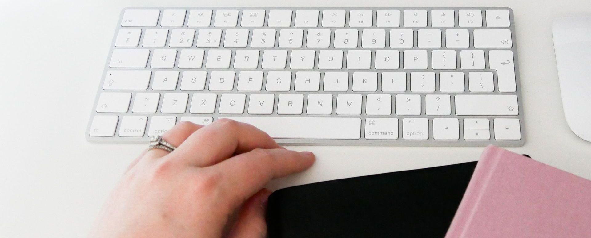 a close up of sophie's hand, a keyboard and some note pads