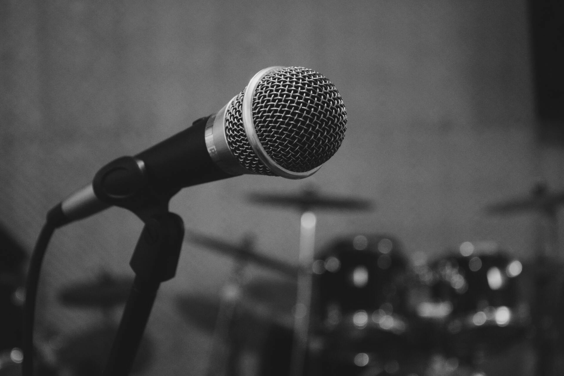 A black and white photo of a microphone on a stand.
