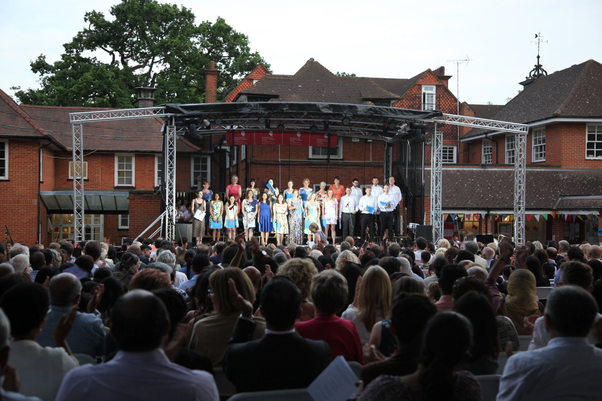 A choir performing on the trailer stage at an outdoor event