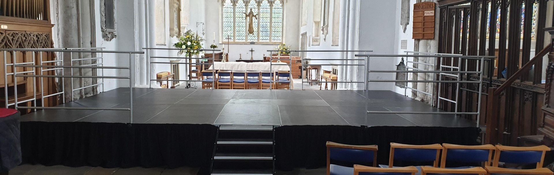 A modular stage set up in a church for an event with steps and handrails