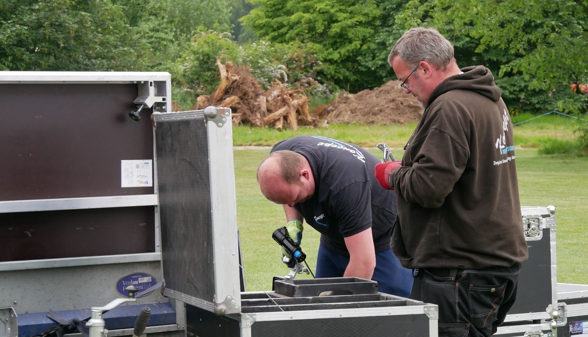 Two crew members on site, looking through flight cases