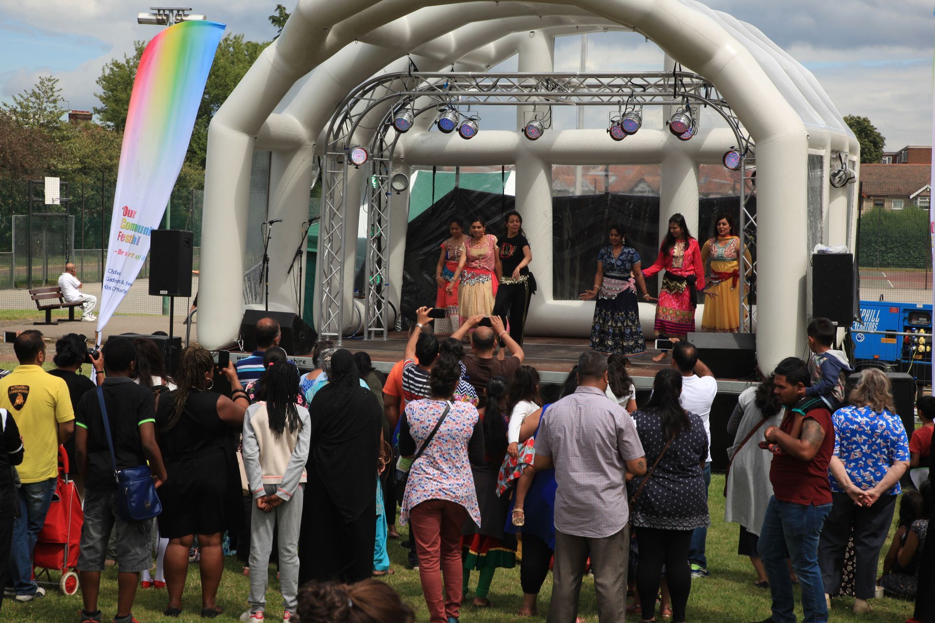 An inflatable roofed trailer stage set up in REdbridge, with a dance act performing on it for an audience