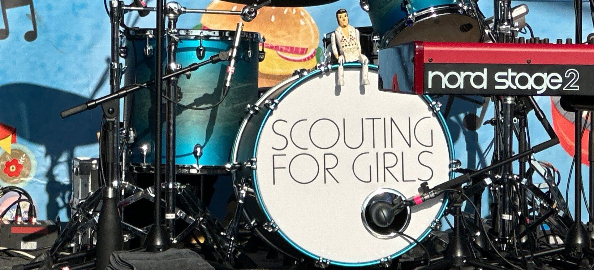 A close up of a drum kit with Scouting For Girls printed on the bass drum.