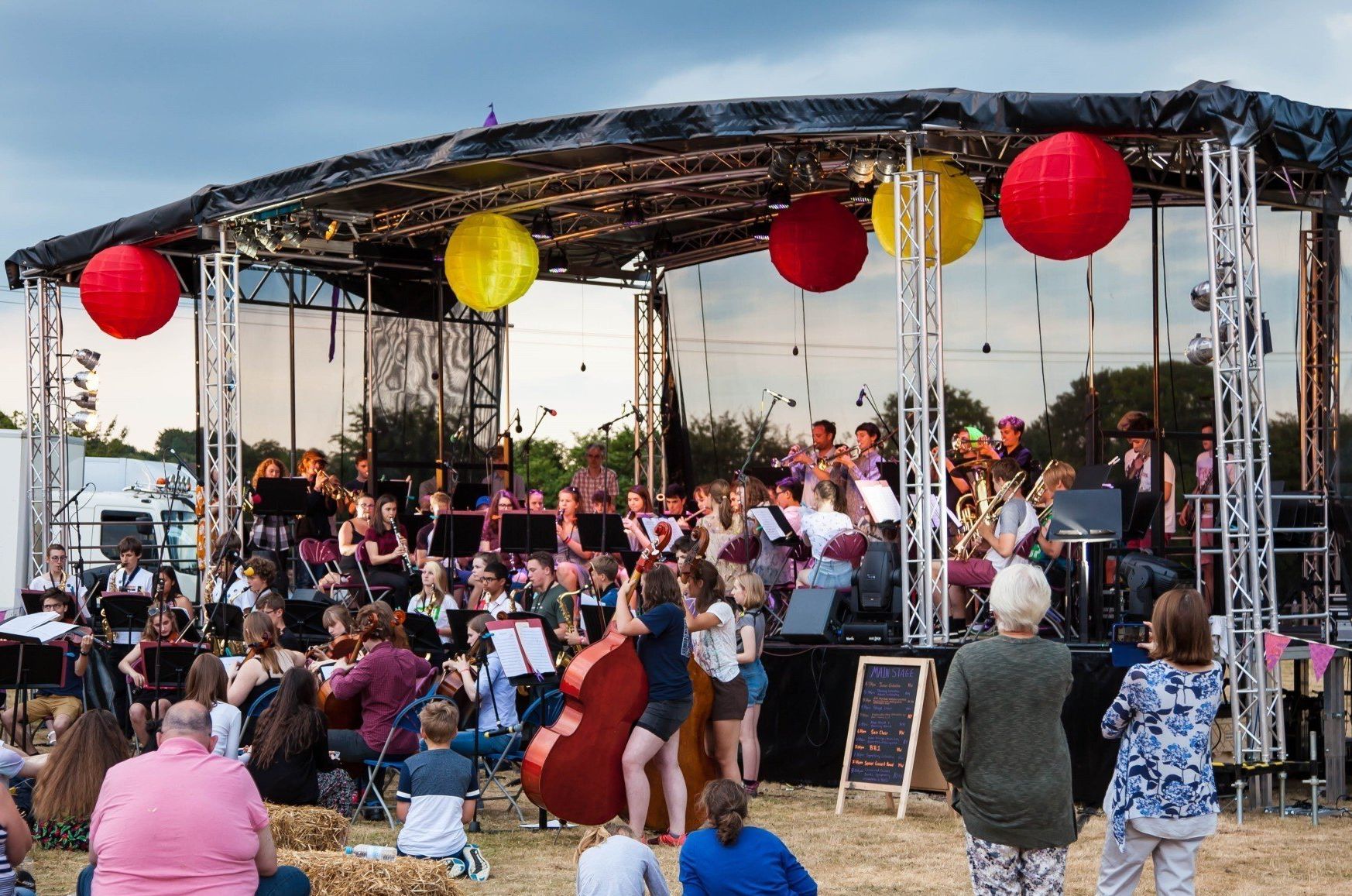 A large trailer stage set up with an orchestra performing on it