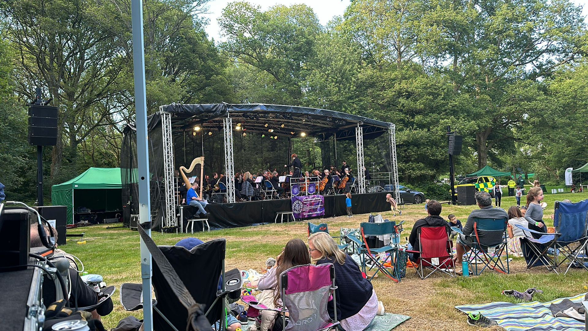 A large trailer stage with a band performing on it in a field