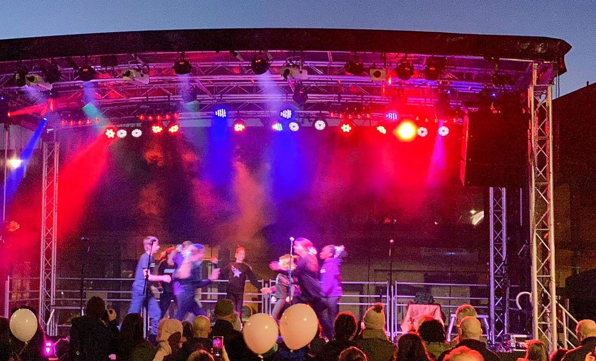 A stage light up in blues and reds with performers on it