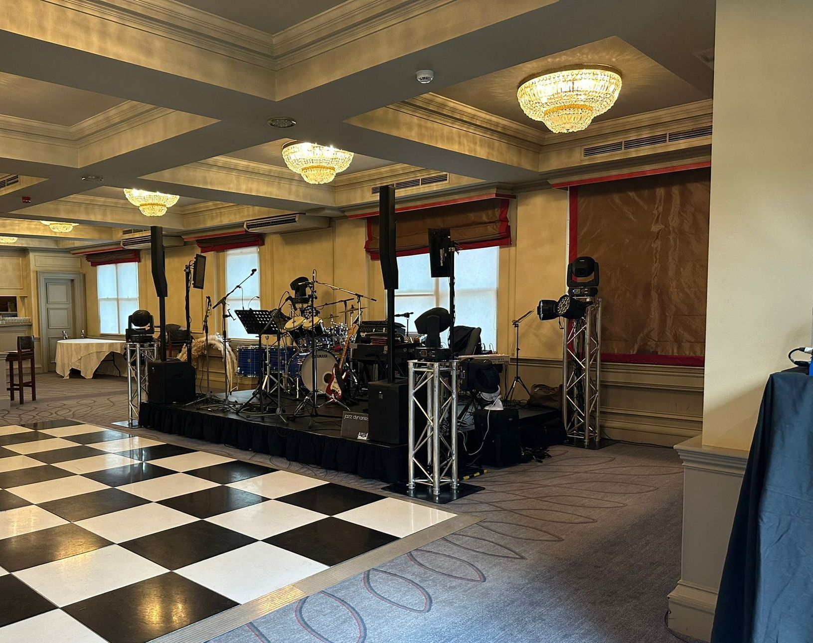 Modular wedding stage set up in an indoor venue with lights and a pa system