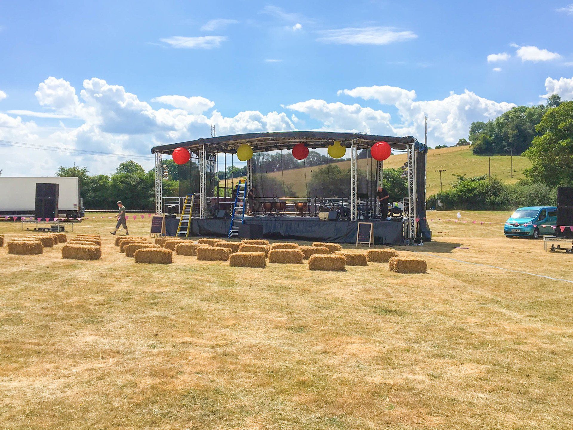 Extra large trailer stage set up for an outdoor event with bunting and hay bails in front of it
