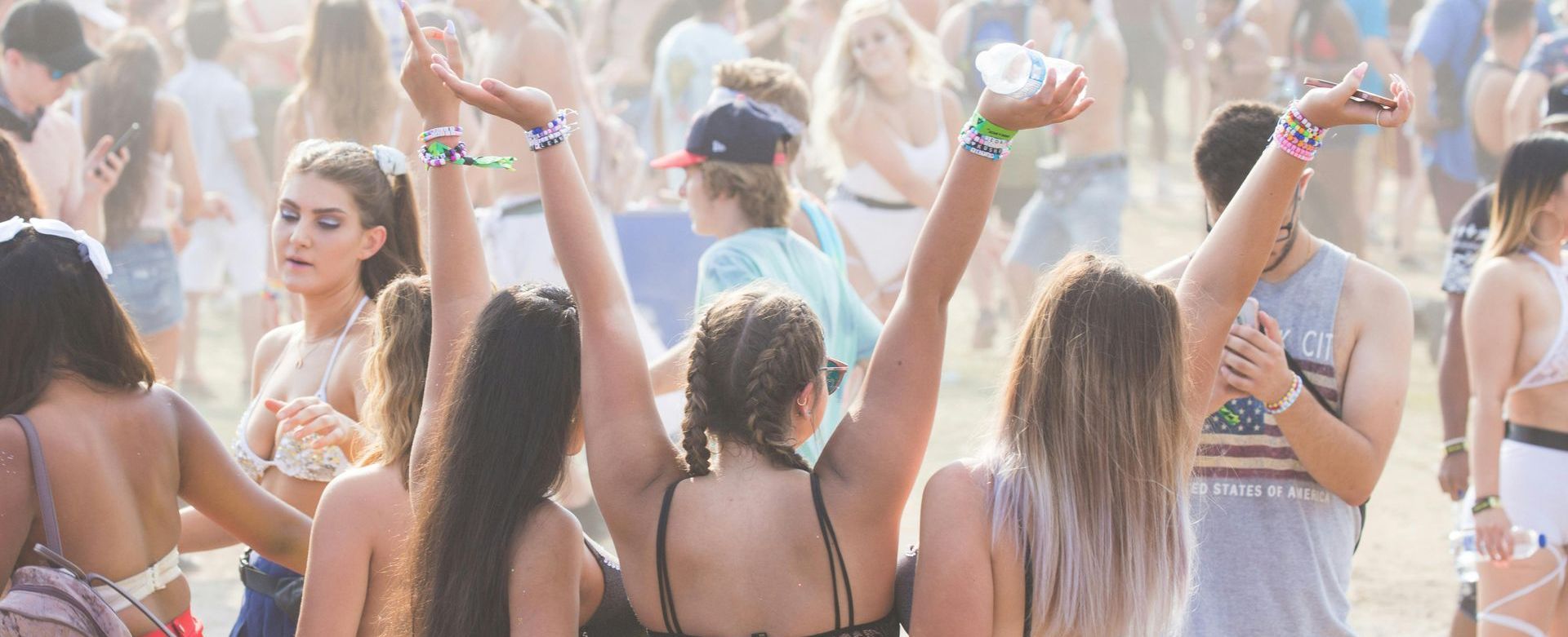 A group of girls at a festival with their backs to the camera. It's soft lighting and spring colours
