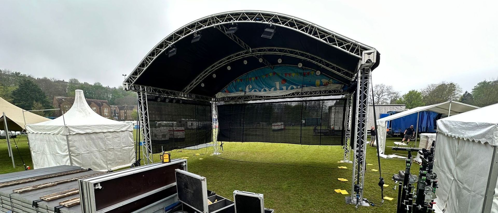 An arc truss stage in the process of being set up in a field